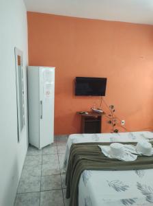 Habitación con 2 camas y TV en la pared. en Apartamento em Angra dos Reis, en Angra dos Reis