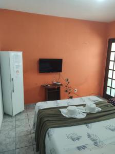a bedroom with a bed and a tv on the wall at Apartamento em Angra dos Reis in Angra dos Reis