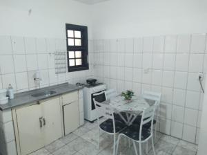 cocina con mesa, fregadero y fogones en Apartamento em Angra dos Reis, en Angra dos Reis