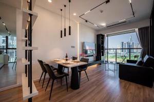 a dining room and living room with a table and chairs at Lè Métropole Saigon in Ho Chi Minh City