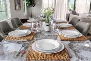uma mesa de jantar com pratos brancos e talheres em Elegant Disney Vacation Home on Reunion Resort em Kissimmee