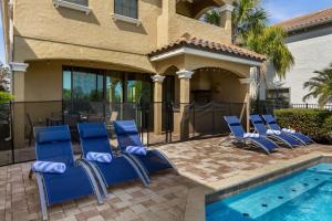 a group of blue chairs next to a swimming pool at Elegant Disney Vacation Home on Reunion Resort in Kissimmee