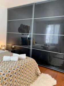 a reflection of a bedroom with a bed and a mirror at L’Emeraude in Villeparisis