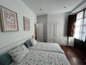 a small bedroom with a bed and a window at Apartamento en el centro de Llanes in Llanes