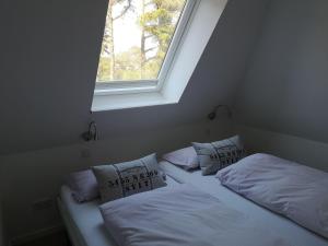 two beds in a room with a window at Strandkoje-Landhaus-Tadsen in Westerland (Sylt)