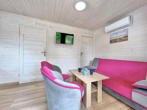 - un salon avec un canapé rose et une table dans l'établissement Chatki u Agatki, à Jezierzany