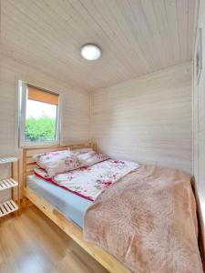 Ce lit se trouve dans une petite chambre dotée d'une fenêtre. dans l'établissement Chatki u Agatki, à Jezierzany
