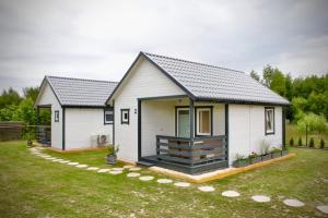 a small white house with a yard at Chatki u Agatki in Jezierzany