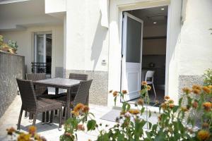 patio ze stołem i krzesłami oraz kwiatami w obiekcie Hotel Villa Centa w mieście Varazze