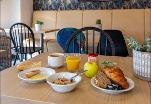 een tafel met borden ontbijtproducten erop bij B&B HOTEL CHARTRES Oceane in Chartres