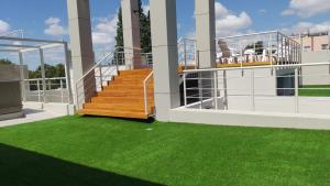 a balcony with stairs and green grass on a building at Nómade Hostel mdz in Mendoza