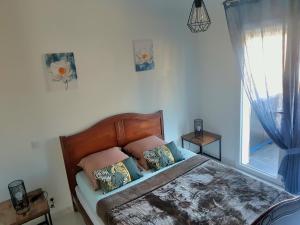 sypialnia z łóżkiem z poduszkami i oknem w obiekcie BORD DE PLAGE LÔNES BONNEGRACE, PORT de SANARY SUR MER w mieście Sanary-sur-Mer