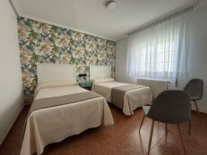 a room with two beds and a window at Luarca Zabala Hotel in Luarca