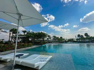a swimming pool with two chairs and an umbrella at Arabian Nights - Oceanfront Luxurious Living at Atlantis The Royal in Dubai