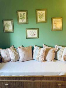 un sofá con un montón de almohadas contra una pared verde en Terrazza Bellavista Suite en Bolgheri