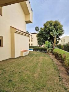 a white building with a bench next to a yard at Apto. Residencial Poniente en San Javier in San Javier