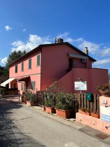 a red building with potted plants in front of it at Appartamenti Lucry in Procchio