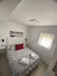 um quarto com uma cama com duas almofadas em J&V Apartamento em Ronda