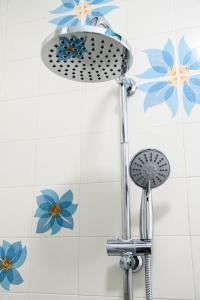 a shower head in a bathroom with blue flowers on the wall at Testa's house Sorrento in Sorrento +37 photos
