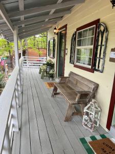 a wooden porch with a bench on a house at Acorn Hideaways Canton Escape to Neverland Suite for 3 in Canton