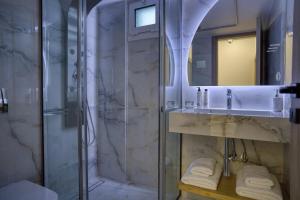 a bathroom with a shower and a sink and a mirror at ELiXiR 2 Luxury apartments in Agios Nikolaos +37 photos
