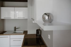 een kleine keuken met witte kasten en een wastafel bij Apartament Giżycko plaża, blisko centrum in Giżycko