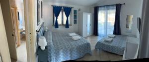 a bedroom with two beds and a window at B&B Le Farfalle in Palau