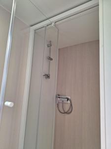 um chuveiro com uma porta de vidro na casa de banho em Camping Mar Estang em Canet-en-Roussillon