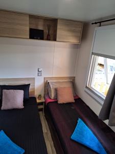 a small room with two beds and a window at Camping Mar Estang in Canet-en-Roussillon