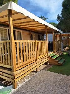 a wooden gazebo with an umbrella and stairs at Camping Mar Estang in Canet-en-Roussillon
