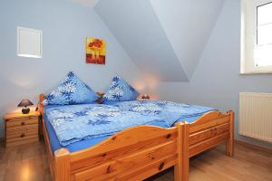 a bedroom with a wooden bed with blue sheets at Ferienwohnung Lena in Stedesdorf bei Esens an der Nordseeküste in Ostfriesland in Stedesdorf