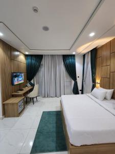 a bedroom with a large bed and a desk at Samuel Court in Abuja