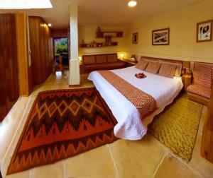 a bedroom with a large bed and a rug at Finca Petrona in Mindo