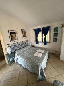 a bedroom with a bed with a blue comforter at B&B Le Farfalle in Palau +43 photos
