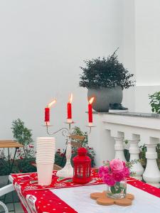 einen rot-weißen Tisch mit Kerzen und Blumen in der Unterkunft La foret Vân Hoà villa 2 in Hanoi