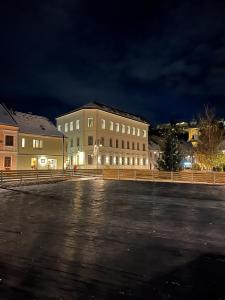 an empty parking lot in front of a building at night at Hotel Atria in Braşov