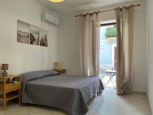 ein Schlafzimmer mit einem Bett und einem großen Fenster in der Unterkunft Casa Maruzzella in Lipari
