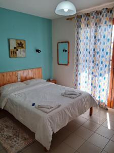 uma cama num quarto com uma parede azul em Δημητρίου em Loutra Edipsou