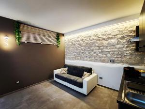 a living room with a white couch and a stone wall at Deluxe in Alberobello