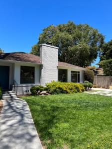 a house with a grass yard and a driveway at One room with one queen bed studio to rent in Palo Alto