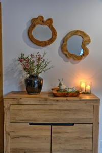 a wooden dresser with two candles and two mirrors at Apartmany pod Pustevnami in Prostřední Bečva