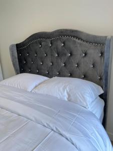 a bed with a black headboard and white pillows at One room with one queen bed studio to rent in Palo Alto