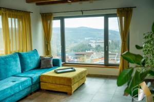 a living room with a blue couch and a large window at Studio54 in Veliko Tŭrnovo