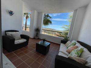 sala de estar con sofá, sillas y ventana grande en Las Brisas de Alhaurín Golf, en Málaga