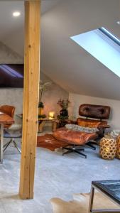 a living room with leather furniture and a skylight at Apartmany pod Pustevnami in Prostřední Bečva