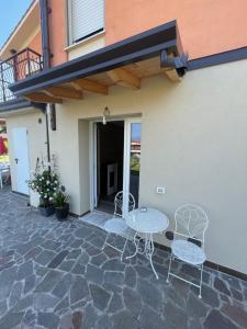 patio z 2 krzesłami i stołem obok budynku w obiekcie Nuovo appartamento a Salò w mieście Salò