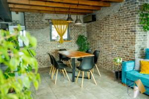 comedor con pared de ladrillo y mesa y sillas de madera en Studio54, en Veliko Tŭrnovo