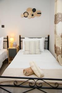 a bedroom with a bed with white sheets and pillows at Old Harbour Aroura 2BR Home in Spetses