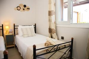 a bedroom with two beds and a window at Old Harbour Aroura 2BR Home in Spetses