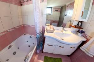 a bathroom with a tub and a sink and a bath tub at Old Harbour Aroura 2BR Home in Spetses